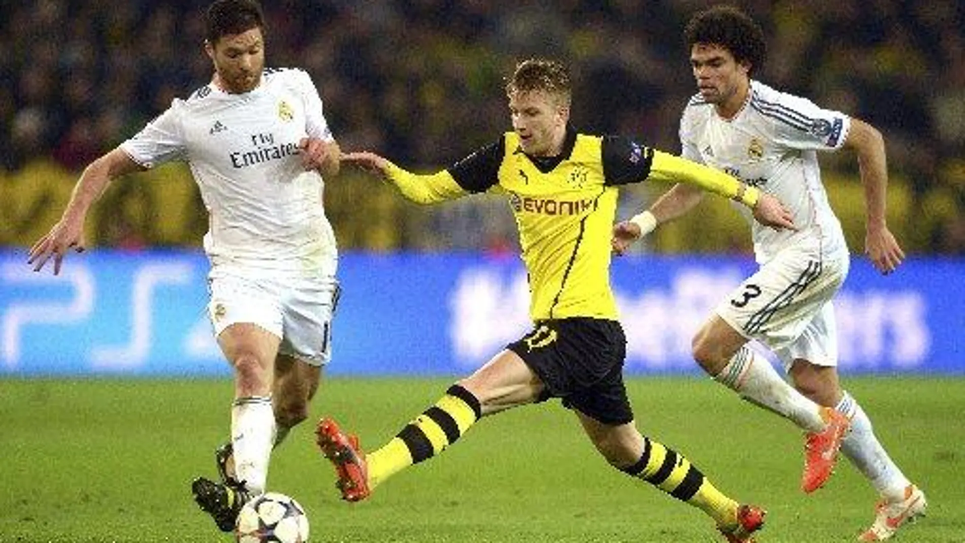 Marco Reus (c), del Borussia Dortmund, en acción ante los jugadores del Real Madrid Xabi Alonso (i) y Pepe