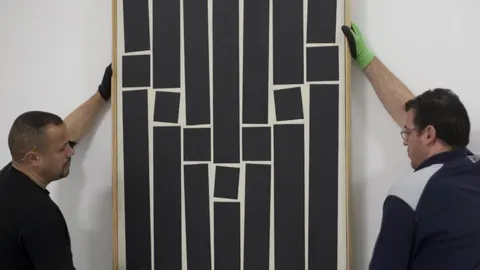 Dos operarios, el viernes, colocan la obra de Helio Oiticica «Brasil painting 9» (1959)