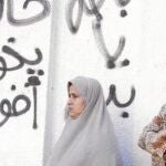 Un grupo de mujeres espera ayer fuera de un colegio electoral en Bani Sweif, al sur de El Cairo