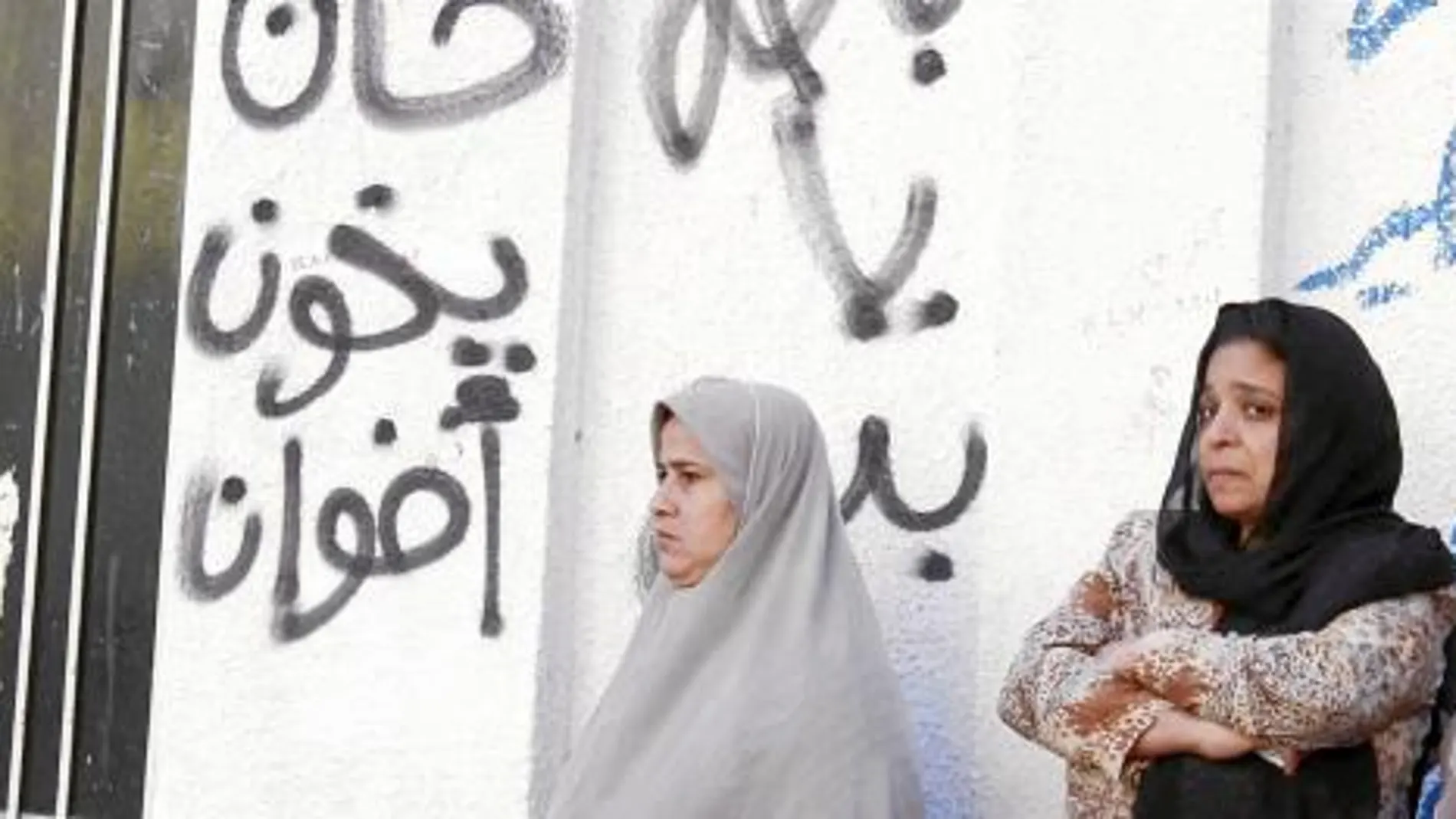 Un grupo de mujeres espera ayer fuera de un colegio electoral en Bani Sweif, al sur de El Cairo