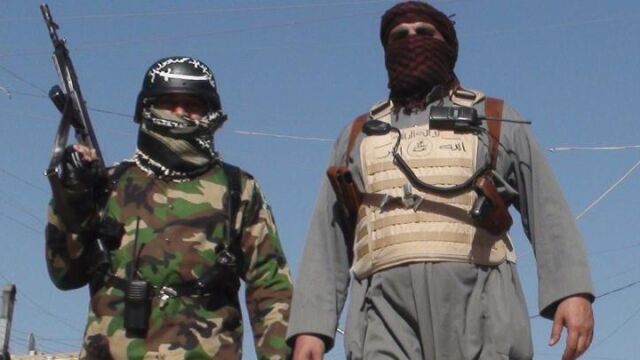 Hombres armados caminan por una calle de Faluya, al oeste de Irak.