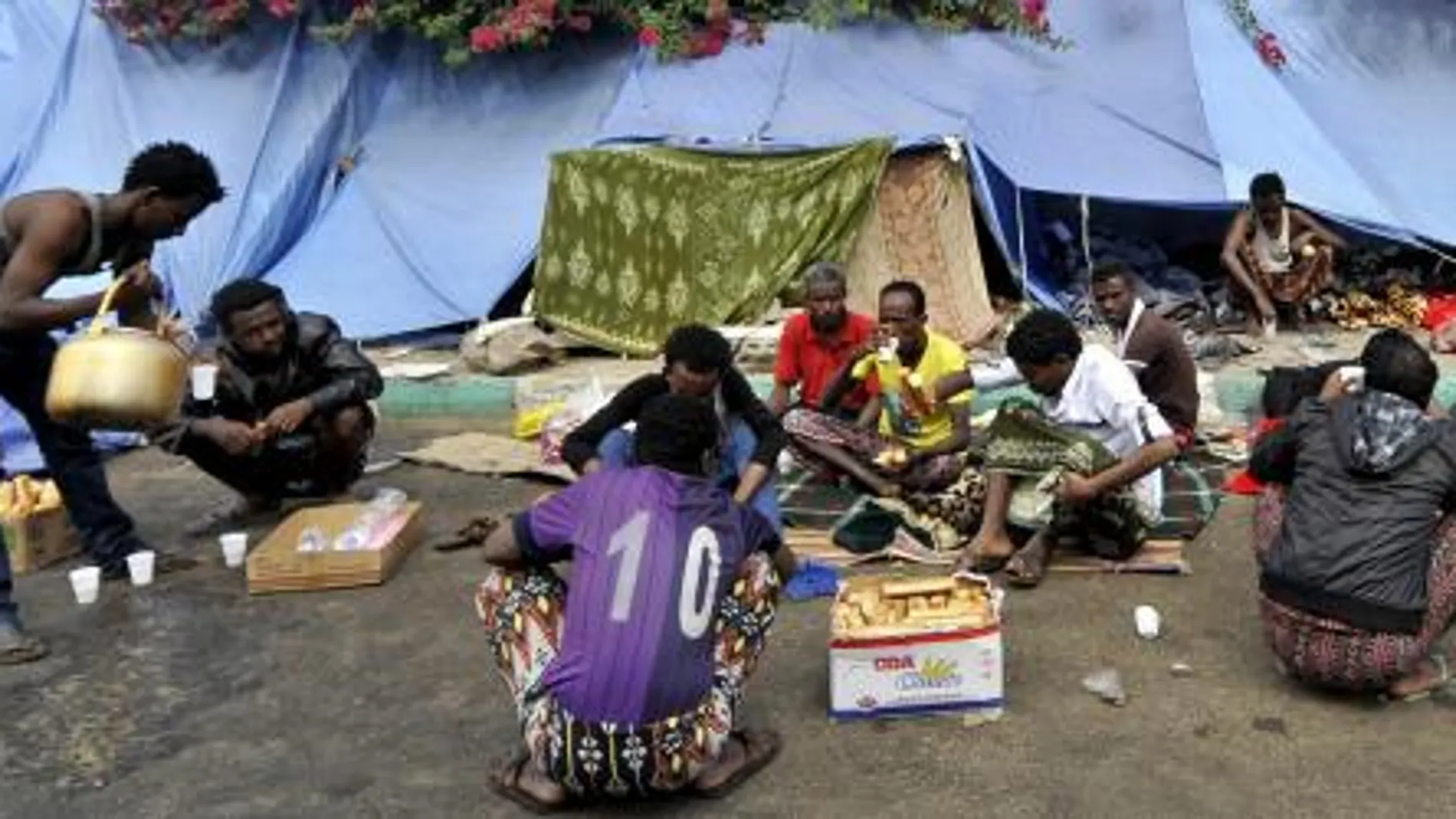 Un grupo de refugiados africanos descansan a la intemperie en un campo de refugiados situado junto a una carretera en Saná (Yemen)
