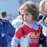 Una voluntaria recoge a un niño que llegó ayer a Sicilia
