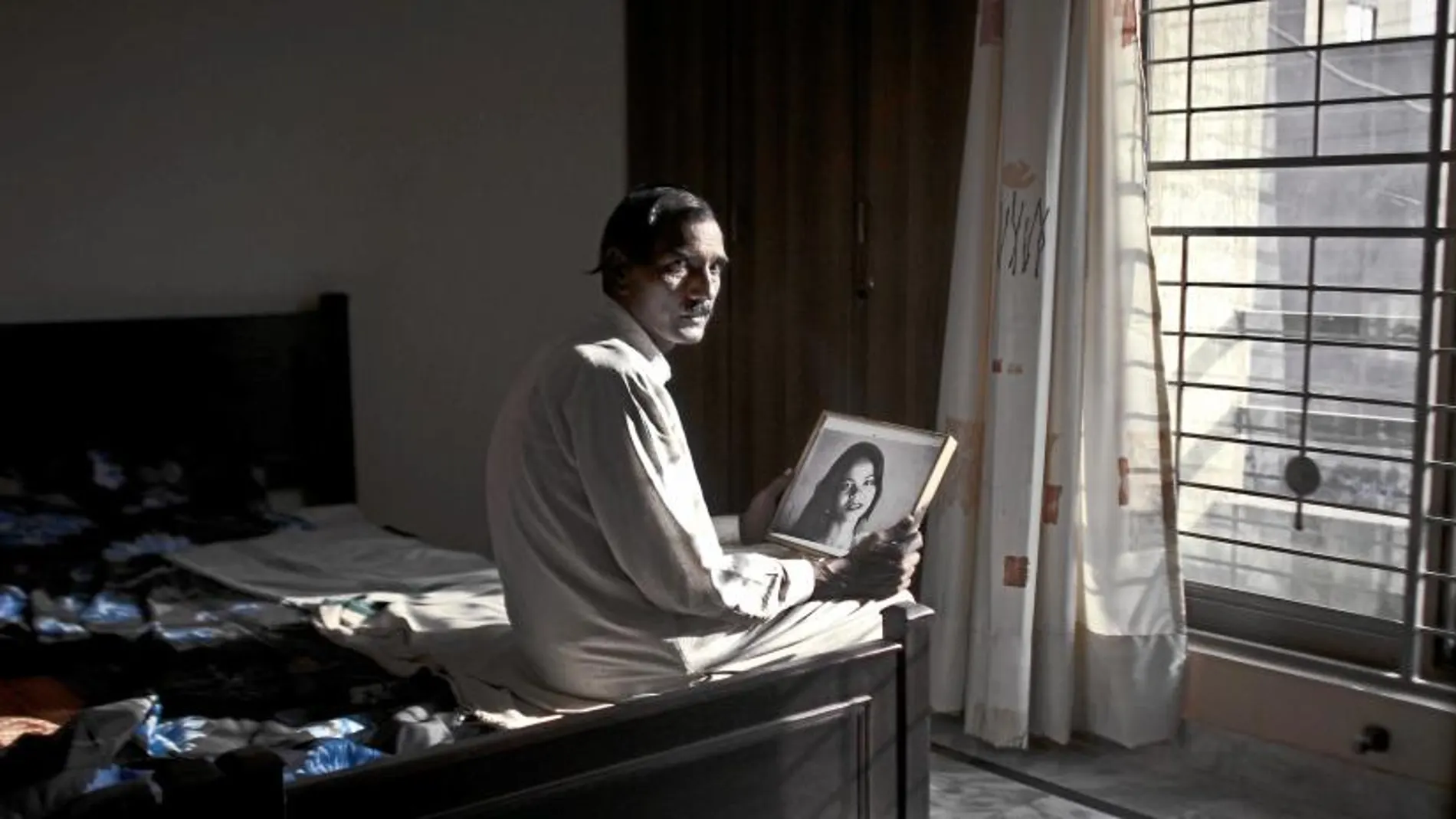 El marido de Asia Bibi contempla el retrato de su esposa, para la que los radicales piden la horca