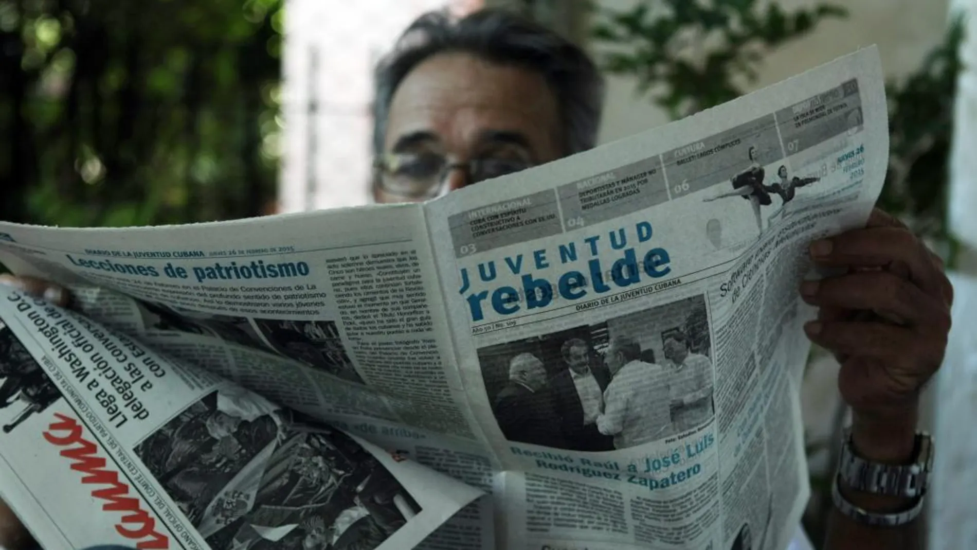 Un hombre lee un periódico cuya portada destaca el encuentro entre el expresidente Rodríguez Zapatero y Raúl Castro