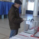 Un hombre busca su nombre en el censo en un colegio electoral en Luhansk, Ucrania.