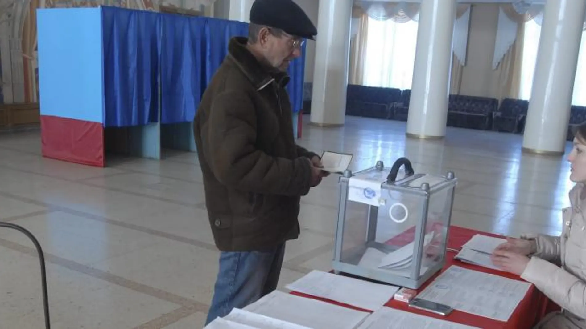 Un hombre busca su nombre en el censo en un colegio electoral en Luhansk, Ucrania.