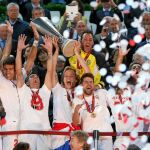 El capitán del Sevilla, Ivan Rakitic (c), sostiene el trofeo de campeones durante la celebración por la victoria ante el Benfica