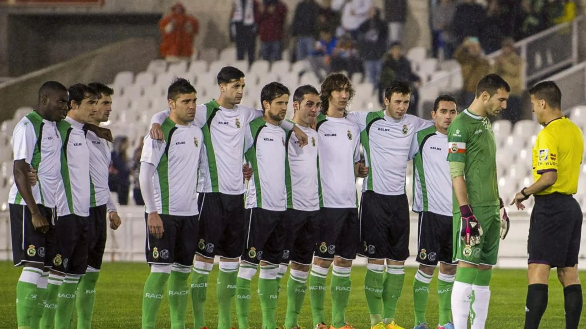 El capitán del Racing de Santander, Mario Fernández (2d), habla con el árbitro, Gil Manzano, flanqueado por sus compañeros tras negarse a jugar el encuentro