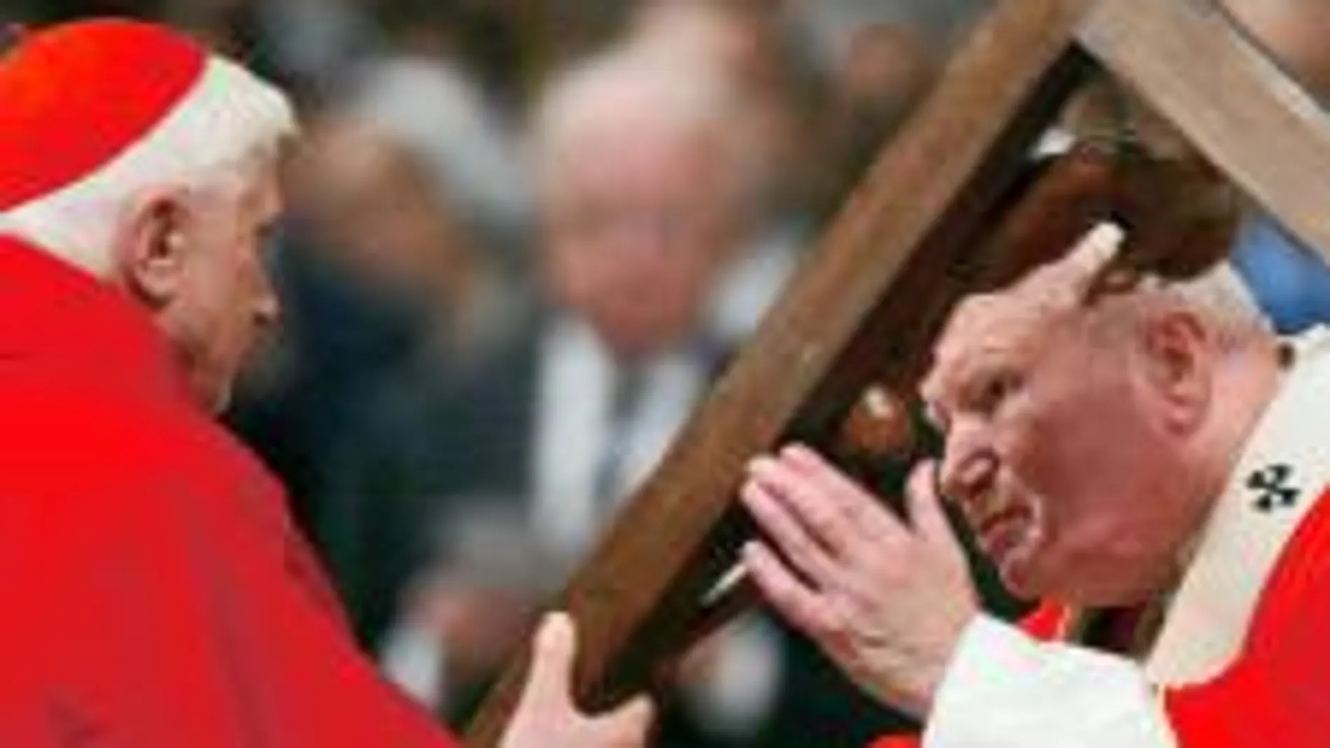 Ratzinger entrega un crucifijo de madera al Papa Juan Pablo II durante la misa de la Pasión del Viernes Santo en la basílica de San Pedro del Vaticano en 2004