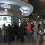 Varias personas hacen cola esta tarde en las taquillas de una conocida sala de cine de Madrid.