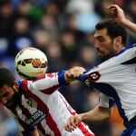 El atlético Arda Turan lucha por un balón y tira de la camiseta al jugador del Espanyol, Anaitz Arbilla