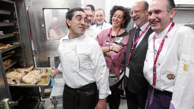 León de la Riva y Mercedes Cantalapiedra bromean con un asador de Castilla y León