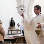 Un sacerdote derrama agua bendita sobre una de las pocas feligresas de ese domingo, en un pueblo de la provincia de Soria