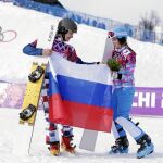 Vic Wild y Alena Zavarnina posan con una bandera rusa después de ganar sus medallas en Sochi