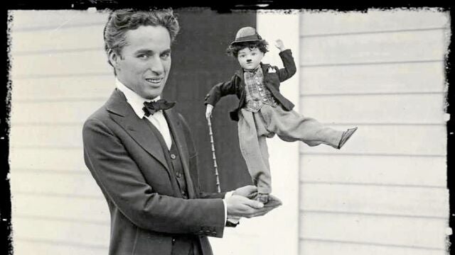 Charles Chaplin, en 1917, sostiene un muñeco con su propia figura