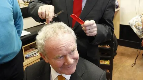 Gerry Adams, de pie, y Martin McGuinness, sentados, en una imagen de 2011.