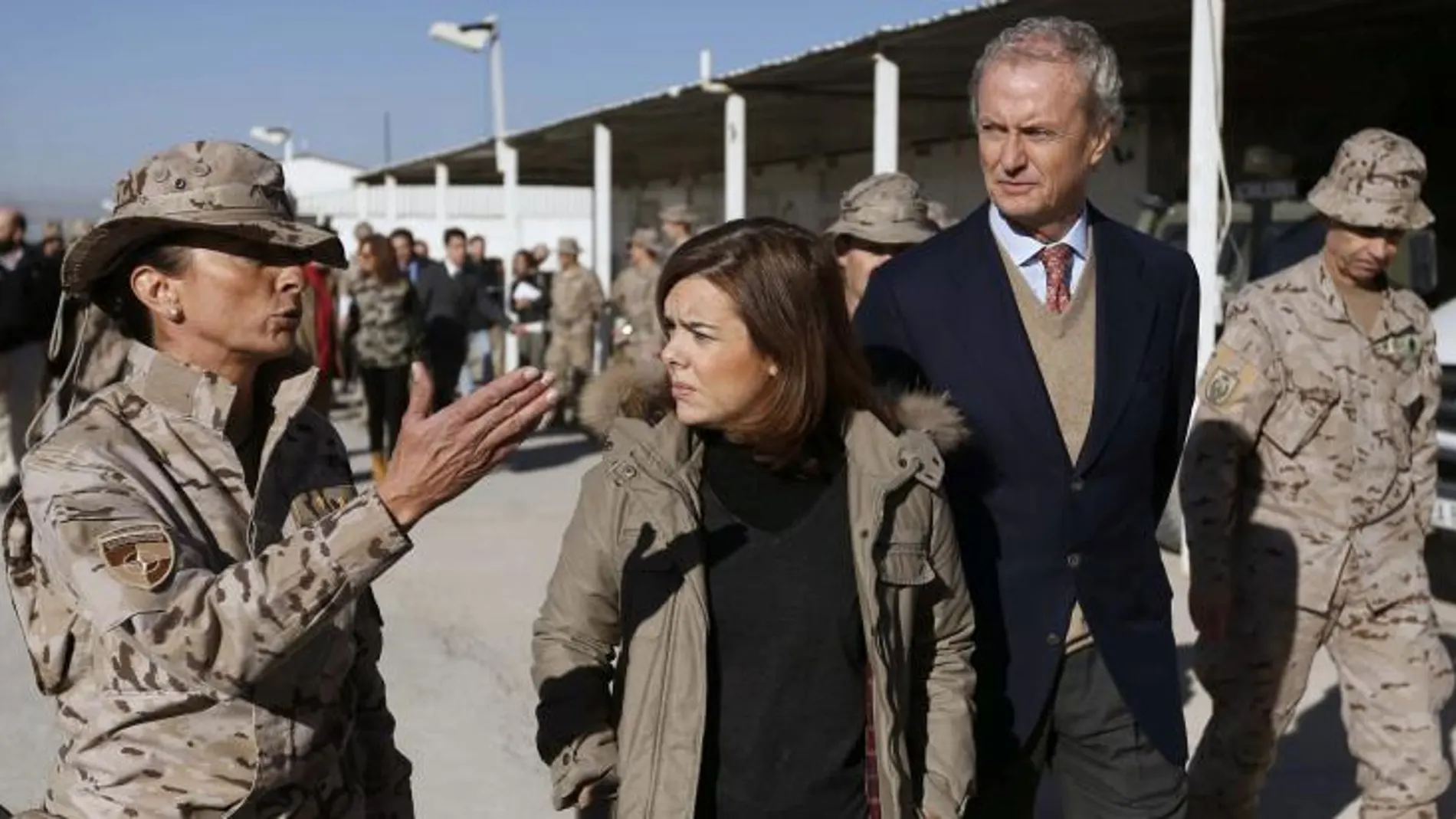 La vicepresidenta del Gobierno, Soraya Sáenz de Santamaría, acompañada por el ministro de Defensa, Pedro Morenés,d., atiende las explicaciones de un mando de la Base de Herat.