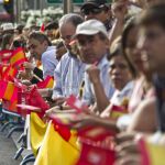 Un centenar de voluntarios del Ayuntamiento reparten banderas de España