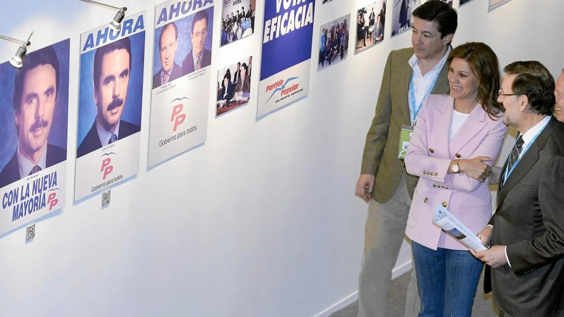 Mariano Rajoy, María Dolores de Cospedal y Pedro Calvo observan algunas fotografías de Aznar en una de las exposiciones de la Convención Nacional de Valladolid