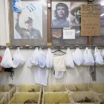 Interior de una fábrica de puros en Cuba con las pertenencias de los empleados metidas en bolsas junto a fotos de Raúl Castro y el Che Guevara