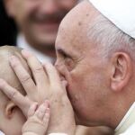 El Papa besa a un niño hoy en Tirana.