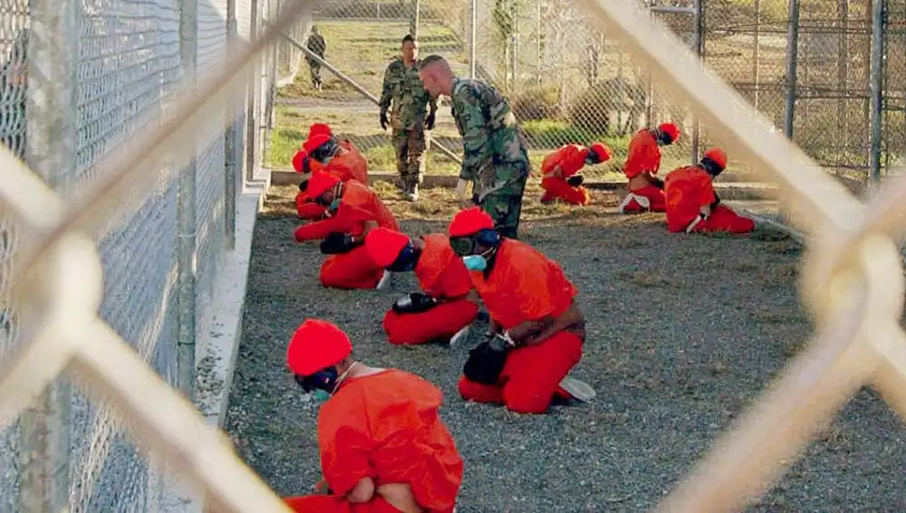 Detenidos en una zona de espera antes de ingresar al centro de detención temporal en Guantánamo