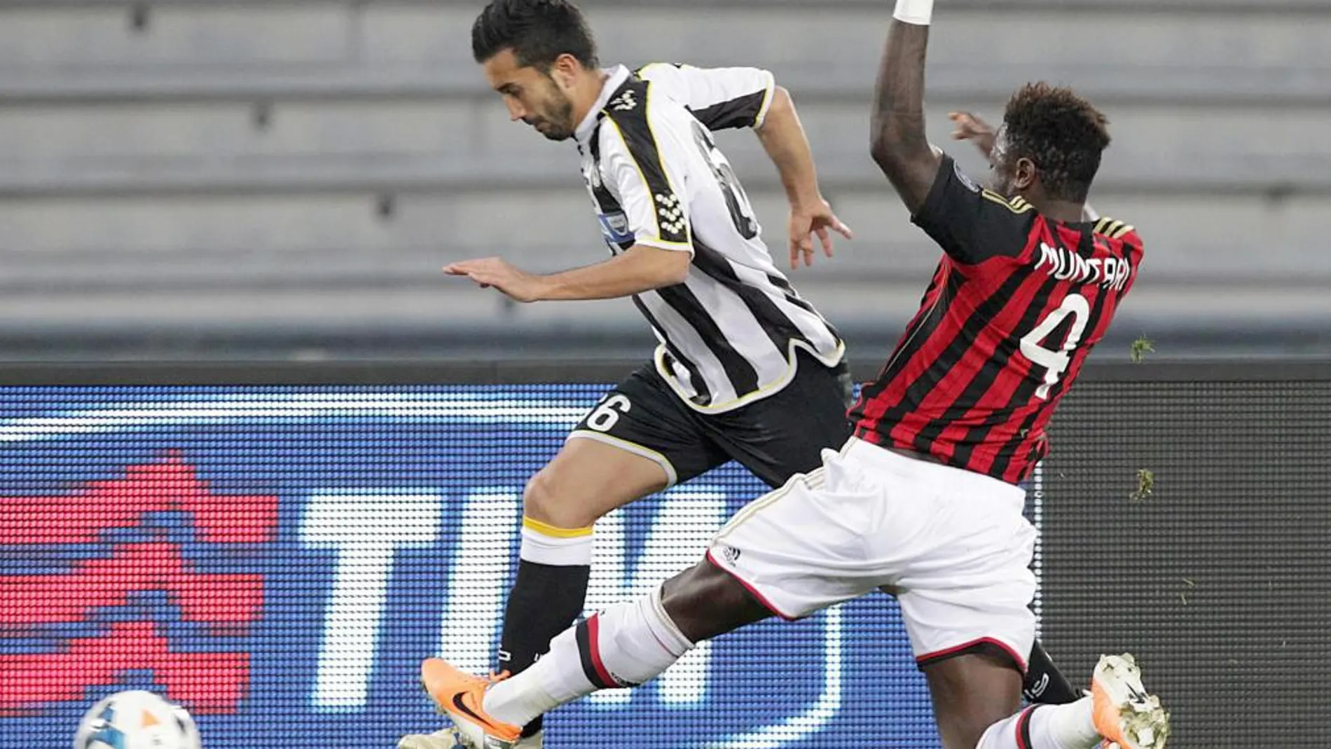 Giampiero Pazzini, del Udinese, supera a Sullay Muntari, del Milan, durante el partido de hoy en Udine.