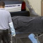 Trabajadores de la morgue retiran el cuerpo de uno de los fallecidos en el tiroteo