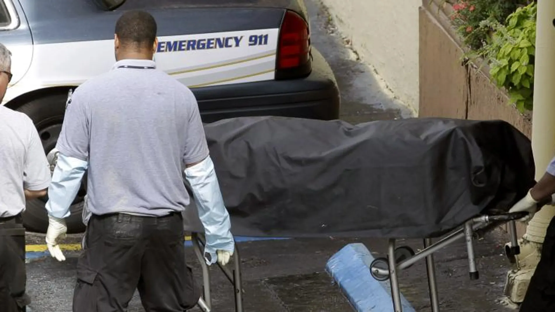 Trabajadores de la morgue retiran el cuerpo de uno de los fallecidos en el tiroteo
