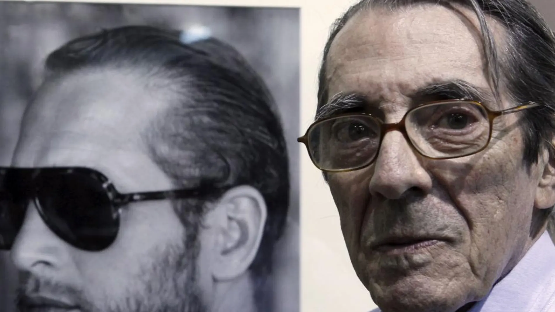 Enrique Meneses posa junto a una instantánea del actor Paul Newman exhibida en una exposición de sus trabajos en 2009