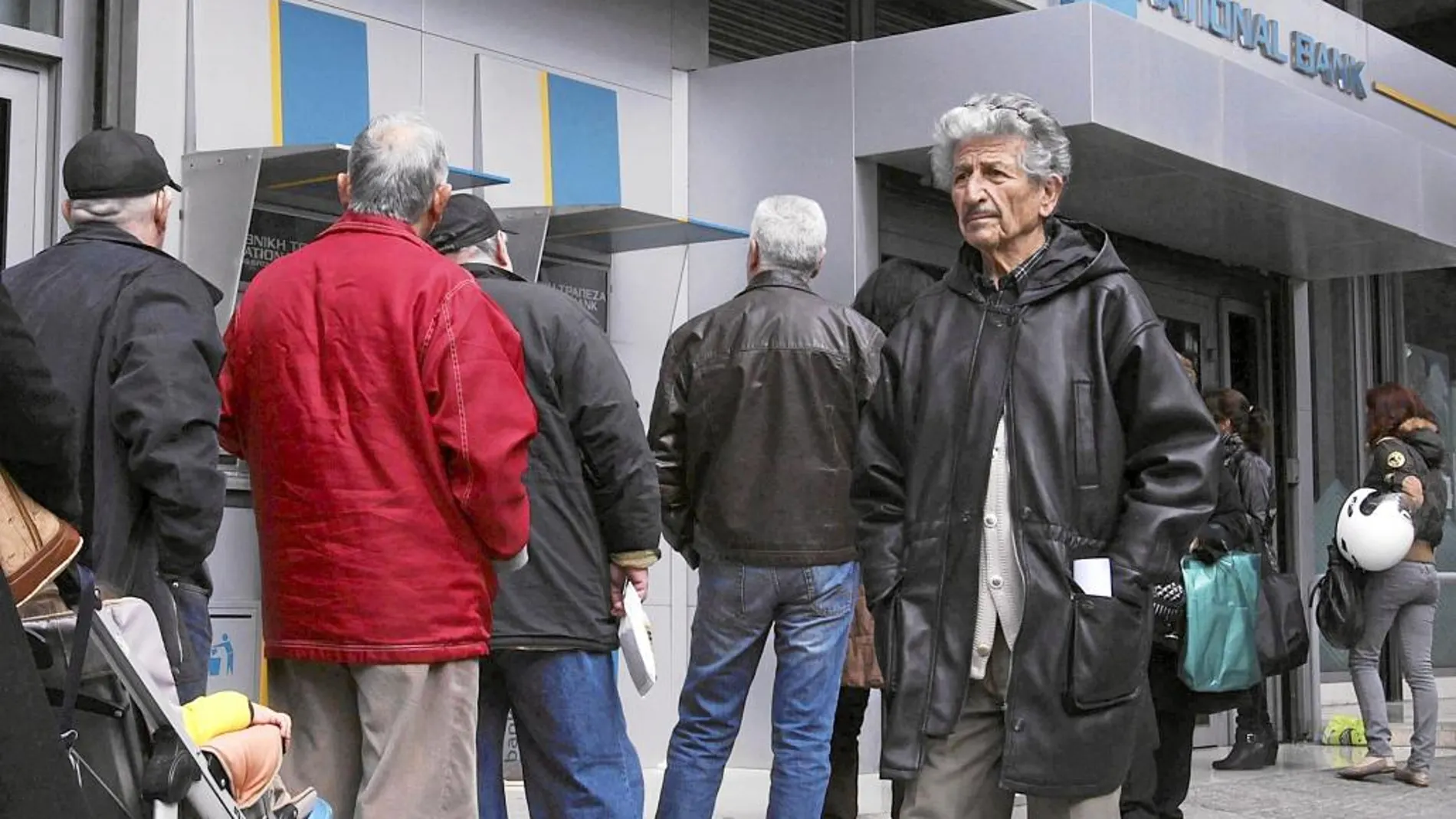 Ciudadanos griegos hacen cola a las puertas de una sucursal bancaria