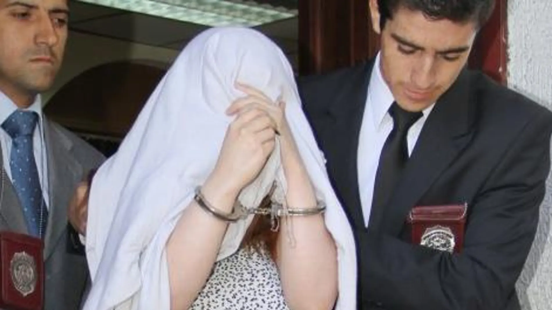La joven sale del juzgado esposada y con la cabeza tapada