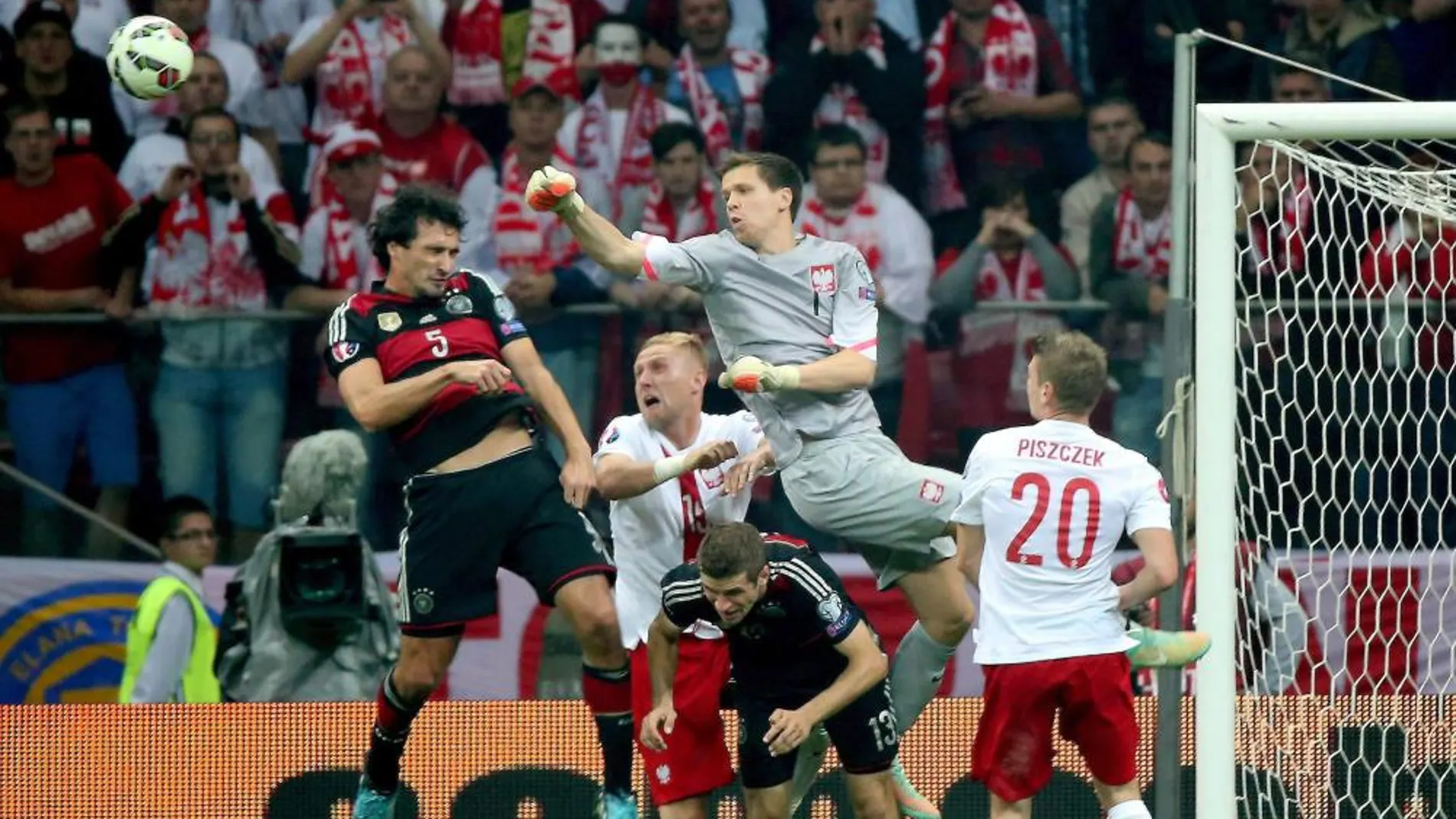 Mats Hummels trata de rematar de cabeza ante la salida del portero polaco, Wojciech Szczesny