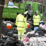 Trabajadores de Tragsa limpian una isla ecológica en el día en el que se cumplieron 15 del inicio de la huelga
