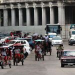 Varios bicitaxis circulan por una calle de La Habana (Cuba)
