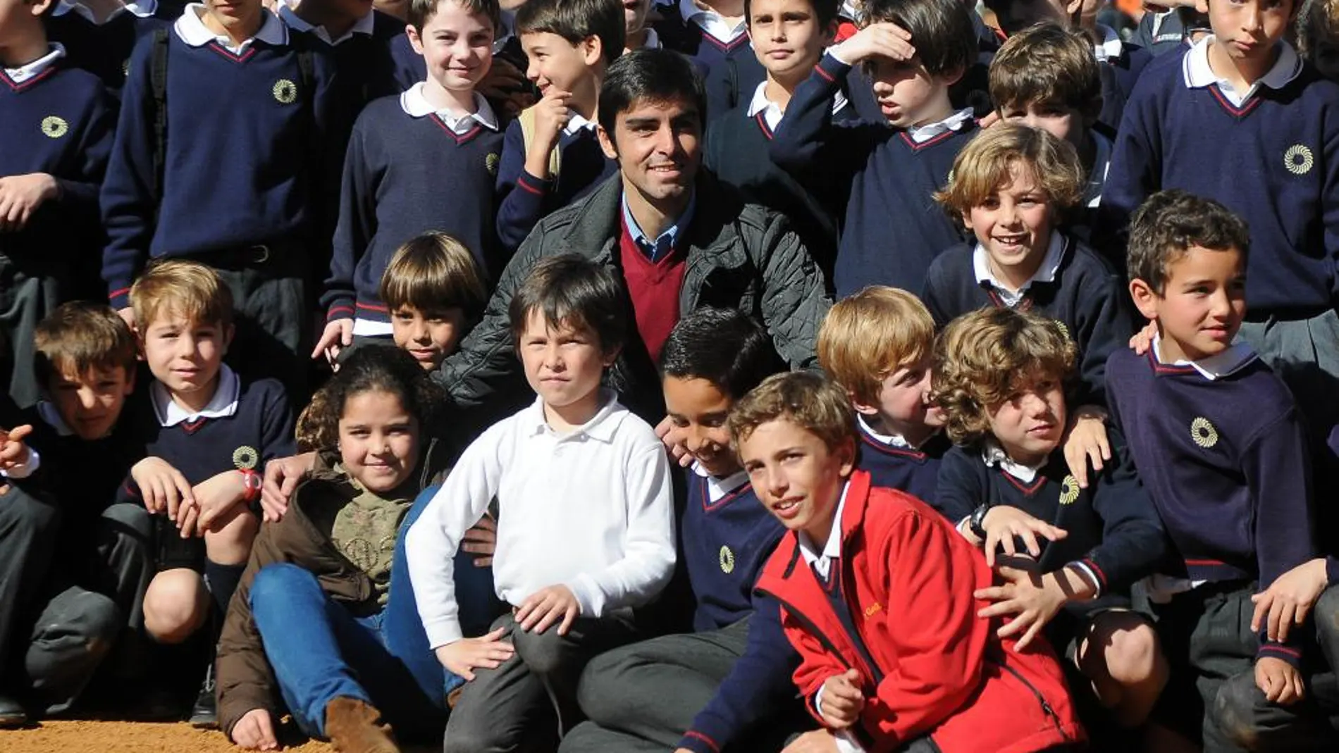 El diestro extremeño posa junto a decenas de niños en el ruedo del coso de Olivenza