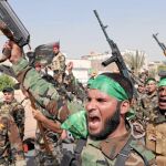 «BRIGADAS DE PAZ». Los milicianos levantan sus armas y corean en contra del EIIL, ayer en Ciudad Sadr, Bagdad
