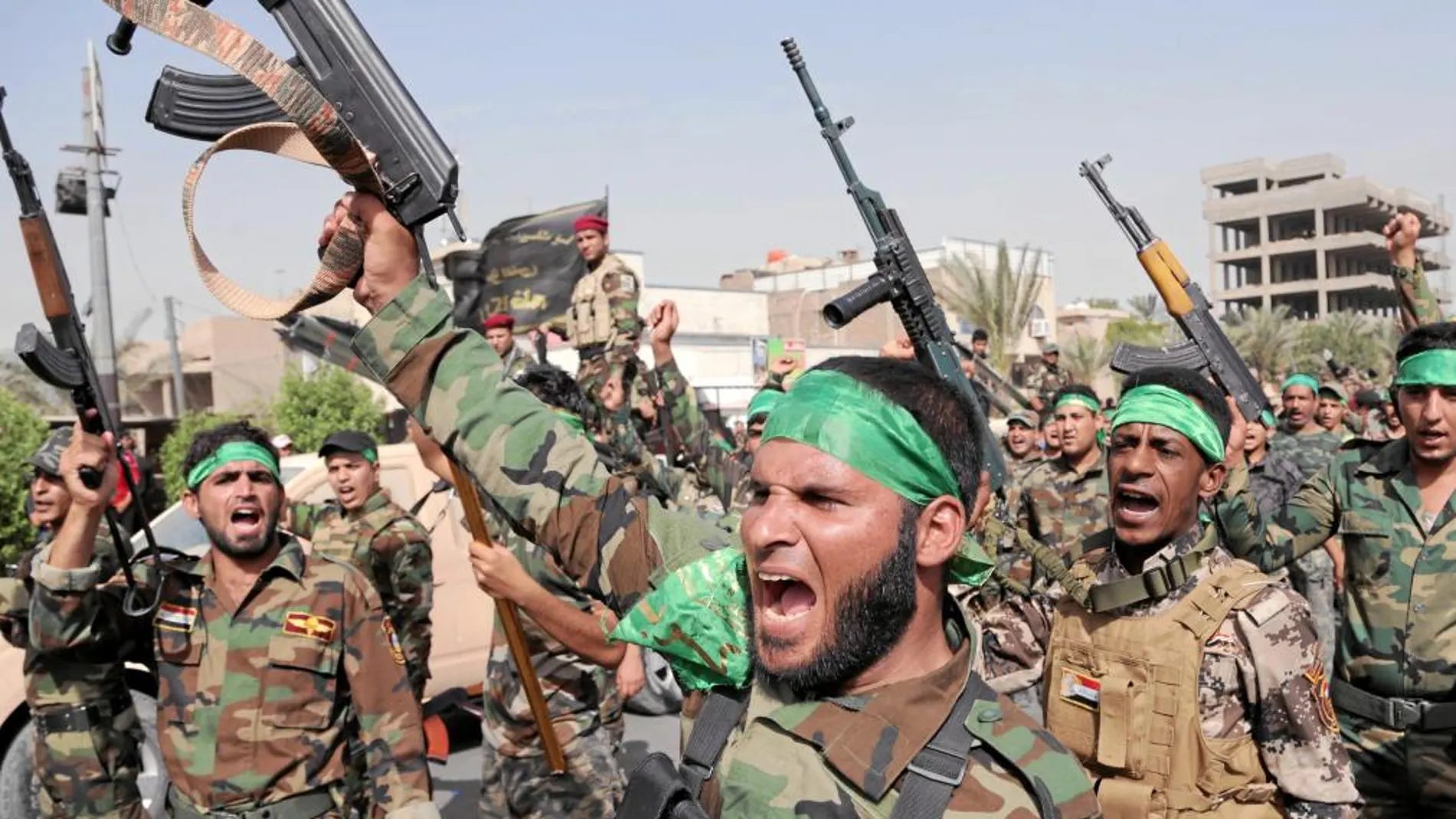 «BRIGADAS DE PAZ». Los milicianos levantan sus armas y corean en contra del EIIL, ayer en Ciudad Sadr, Bagdad