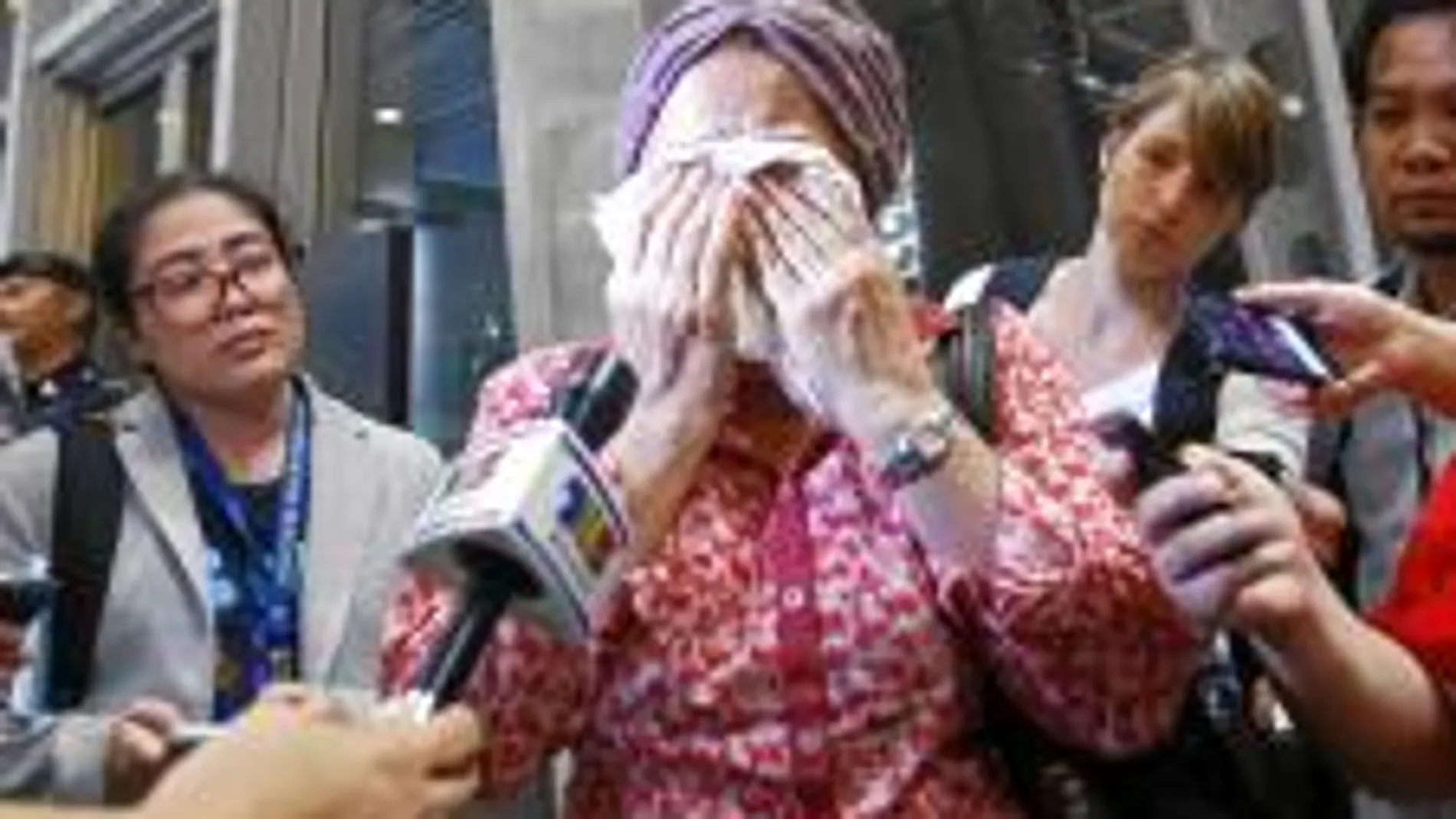Una mujer en Kuala Lumpur llora tras conocer la noticia