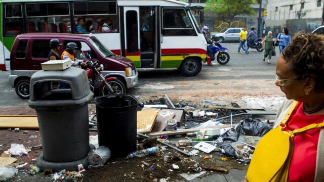 Una mujer camina por una calle, lugar de las protestas en contra el gobierno del presidente venezolano Nicolás Maduro en el municipio Chacao en Caracas