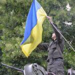 Un soldado ucraniano coloca la bandera de Ucrania en su vehículo militar en el centro de Slaviansk.