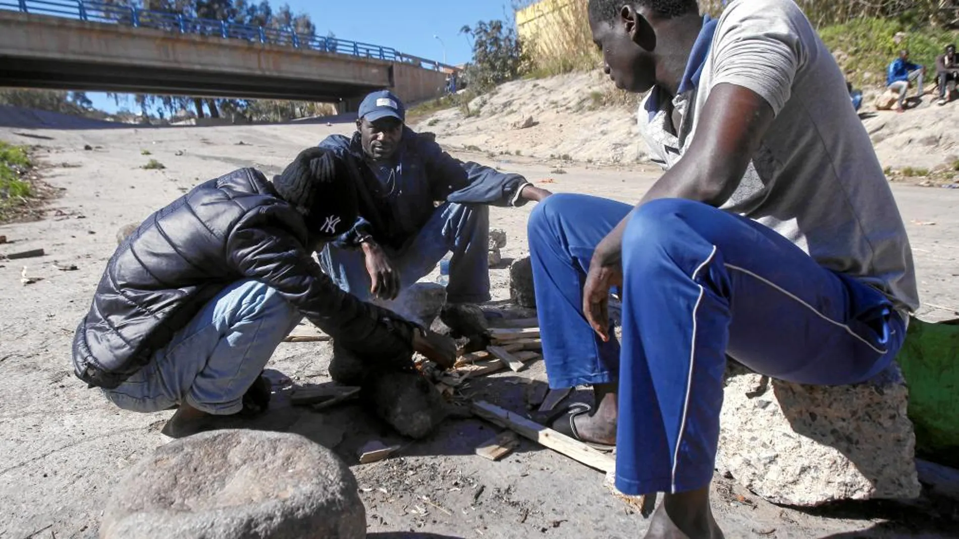 Inmigrantes de Mali preparan un fuego ayer junto al CETI de Melilla