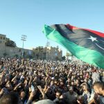 Libios ondean su bandera durante el funeral de unos manifestantes asesinados durante una protesta, en Trípoli hace casi dos años