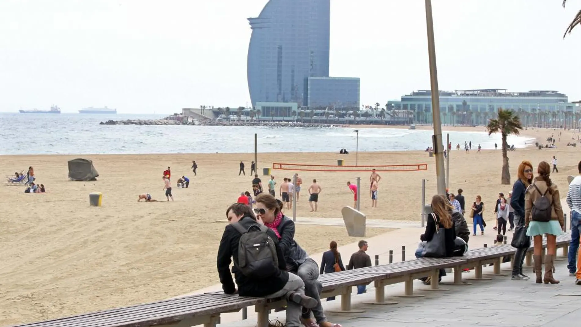Varias personas junto a la playa de Barcelona