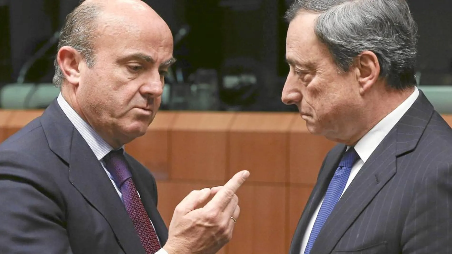 El Ministro de Economía, Luis de Guindos, charla con Mario Draghi, ayer
