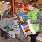 En la imagen, varios ciudadanos entregan alimentos para la campaña del Gran Recapte