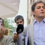 Oriol Pujol saliendo esta mañana de la casa de su padre mientras una decena de personas le increpaban y mostraban pancartas con el lema "Pita por Pujol, Honorable Ladrón"y "5%?"