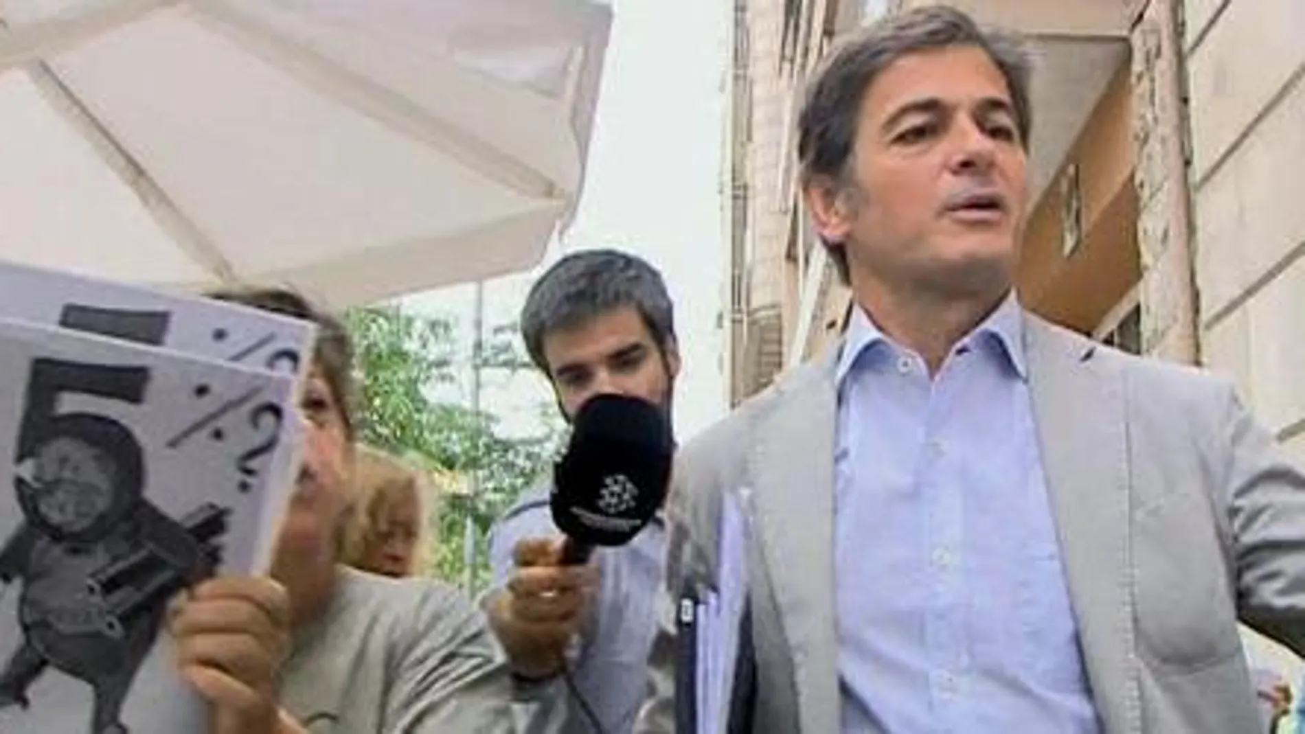 Oriol Pujol saliendo esta mañana de la casa de su padre mientras una decena de personas le increpaban y mostraban pancartas con el lema "Pita por Pujol, Honorable Ladrón"y "5%?"