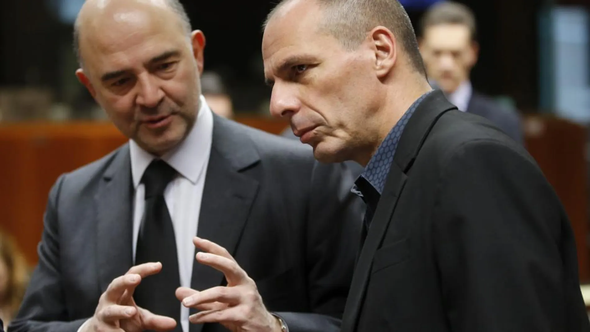 El comisario europeo de Asuntos Económicos y Financieros, Pierre Moscovici conversa con el ministro griego de Finanzas, Yanis Varoufakis